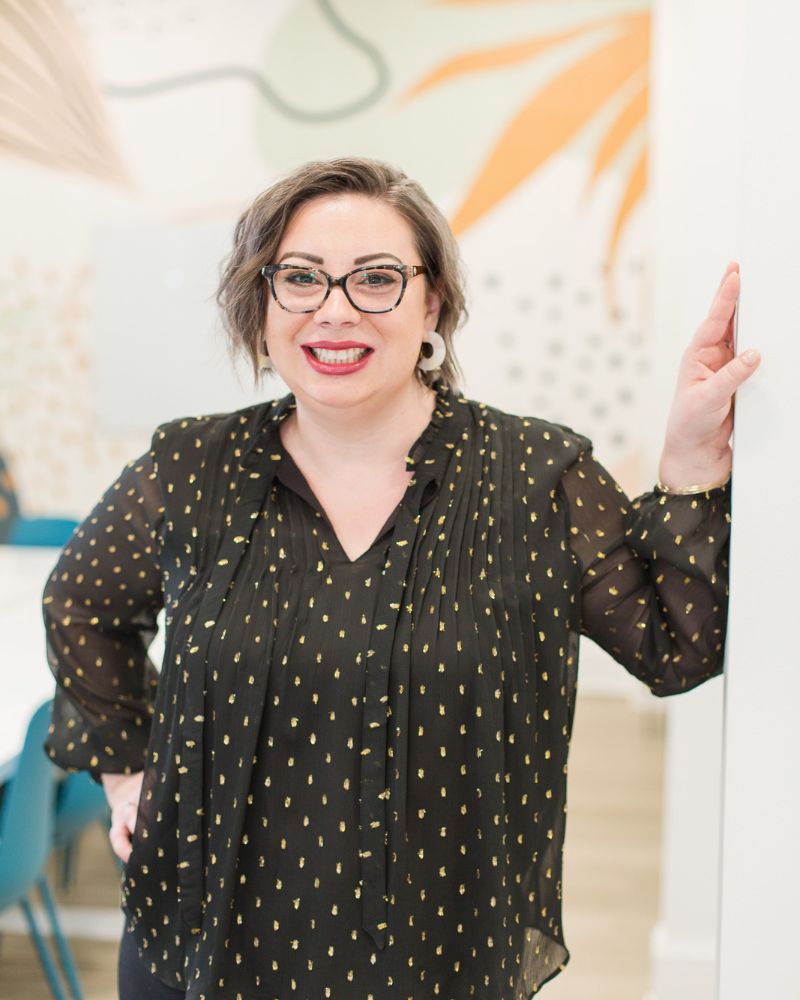 Racheal smiling in a black blouse